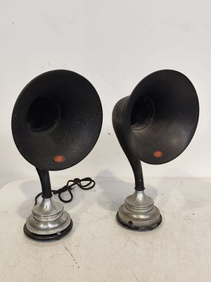 une paire d'enceintes noires et argentées posées sur une surface blanche