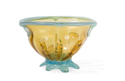 un bol en verre jaune et bleu posé sur une surface blanche