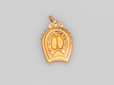 un pendentif en or surmonté d'une couronne