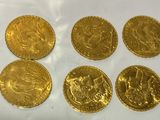 six gold sovereigns of different sizes and shapes