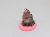 a small statue of a person sitting on top of a pink object
