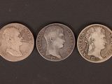 three different types of coins are shown on a black surface