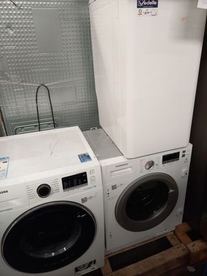deux lave-linge et un sèche-linge dans une petite pièce