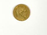 a gold coin on a white surface with a white background