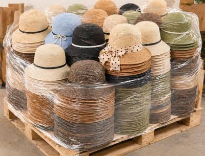 de nombreux chapeaux emballés dans du plastique sur une palette