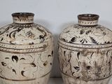 two vases sitting side by side on a table