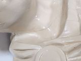 a white statue of a man with a hat on