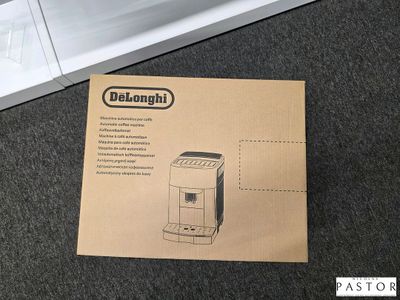 emballage d'une machine à café Delonghi posé par terre à côté d'une cafetière