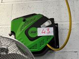 a green blower sitting next to a fan on the wall