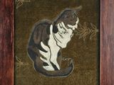 tableau représentant un chat assis dans un cadre en bois sur un fond marron