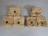 four tan canvas pouchs with buttons on them sitting on a table