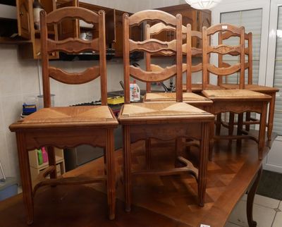 quatre chaises en bois posées autour d'une table dans une cuisine