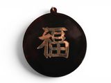 une photo d'un pendentif sur lequel figure un caractère chinois