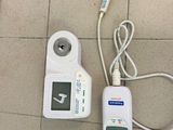 une télécommande et un chargeur posés par terre
