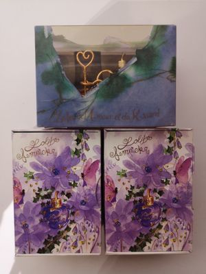 deux boîtes ornées de fleurs violettes, posées sur une table