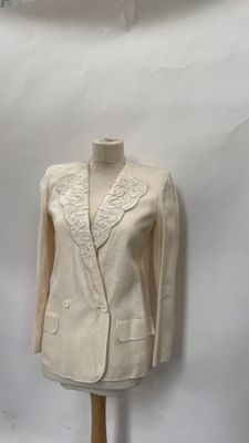beige jacket on a mannequin stand against a white backdrop