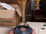une table en bois sur laquelle est posé un disque, avec un tourne-disque posé dessus