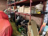 a red car parked in a garage next to a shelf full of boxes