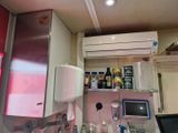 une petite cuisine équipée d'un réfrigérateur, d'un micro-ondes et d'autres ustensiles posés sur le plan de travail