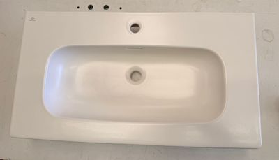 a white sink sitting on top of a white counter