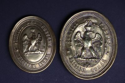 two silver coins with the image of a man and a woman on them