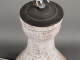 a white vase with a black lid on a table