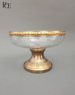 une image représentant un bol en or et en verre posé sur un socle
