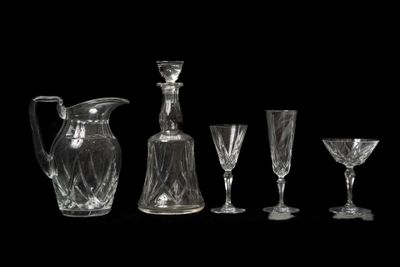 quatre verres à vin et une carafe sur fond noir