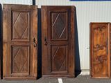 four wooden doors sitting in a parking lot next to each other