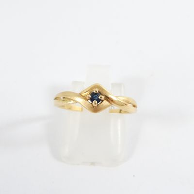 a close up of a gold ring with a sapphire stone