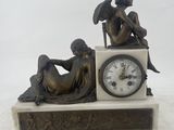 a statue of a man and a woman sitting on a clock