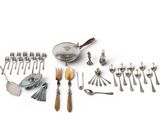 many different types of silverware and spoons laid out on a table