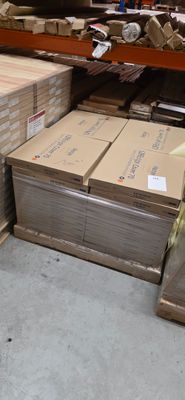 des piles de cartons et des palettes en bois dans un entrepôt