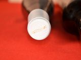 two bottles of wine sitting on a red cloth