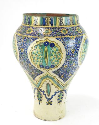 un vase bleu et jaune posé sur une surface blanche