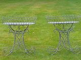 two metal planters sitting on the grass in the yard
