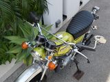 a yellow and black motorcycle parked next to a white fence