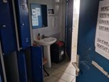a bathroom with blue lockers and a sink in it