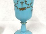 a blue glass with a gold decoration on it