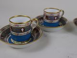 three cups and saucers are sitting on a white surface