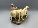 a figurine of a man with two cows