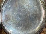 a silver pocket watch sitting on a wooden table