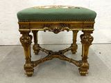 a gold bench with a green cushion on it