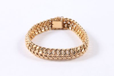 a close up of a gold bracelet on a white background