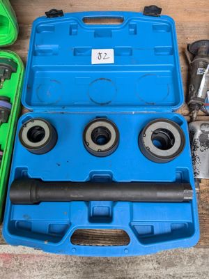 une boîte à outils bleue contenant des outils, posée sur une table en bois