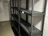 a long black shelf in the middle of a tiled room