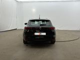the rear end of a black car in a white room