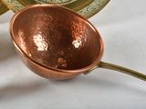 a bowl and a spoon on a table with a clock in the background