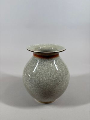 a gray vase with a brown rim sitting on a table