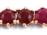 a close up of a row of red stones on a white surface